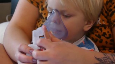 Çocuk bir oksijen maskesi ile nefes alır. Çocuk kez içe çekme sağlar öksürük, grip ve viral hastalıkları alır. Çocuk astım ilacı tıbbi maskesi ile nefes.