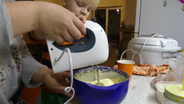 那男孩用搅拌机把馅饼杯混合了 孩子准备了一个蛋糕 — 图库视频影像