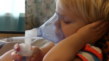 Çocuk bir oksijen maskesi ile nefes alır. Çocuk kez içe çekme sağlar öksürük, grip ve viral hastalıkları alır. Çocuk astım ilacı tıbbi maskesi ile nefes.