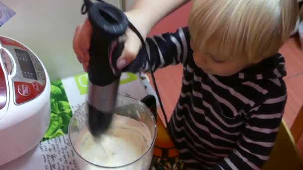 母子用搅拌机搅拌馅饼的成分 一个孩子和他的母亲准备蛋糕与搅拌机 — 图库视频影像