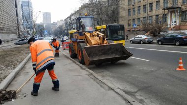 Kiev, Ukrayna - Ocak 2019: Siyasi reklam görüntü Başkan adayı Vladimir Zelensky ile. Yol yardımı çalışanlarına kaldırıma at. Kaldırıma, büyük traktör çöp temizler.