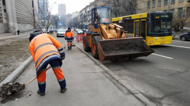 Kiev, Ukrayna - Ocak 2019: Siyasi reklam görüntü Başkan adayı Vladimir Zelensky ile. Yol yardımı çalışanlarına kaldırıma at. Kaldırıma, büyük traktör çöp temizler.