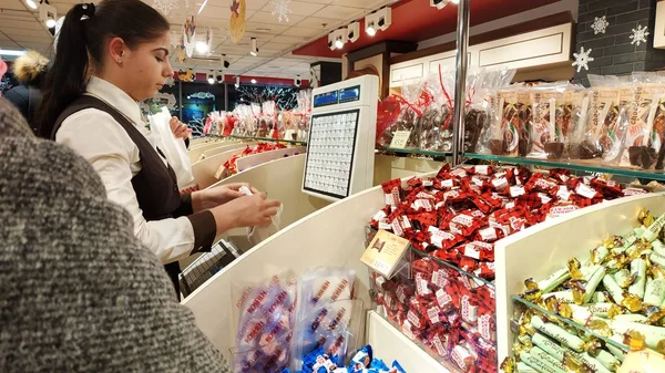 Kiev, Ukrayna - Şubat 2019: RoHS mağaza çalışanı şeker ağırlığındadır. Tatlılar RoHS ile counter.