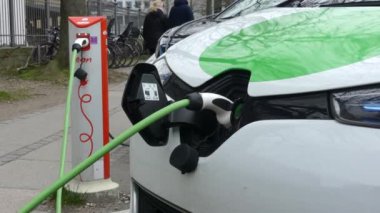 Kopenhag, Danimarka-Mart 2019: elektrikli arabalar otoparkta şarj oluyor. Şehirdeki bir sokakta elektrikli araçların şarj edilmesi.