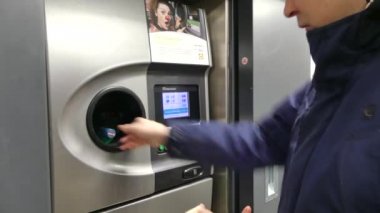 Kopenhag, Danimarka-Mart 2019: bir adam otomatik bir alıcı şişe boş kabinleri koyar. Ters otomat geri dönüşüm makinesi. Nakit dağıtır geri dönüşüm makinesi. Adam el makineye plastik şişe koyar
