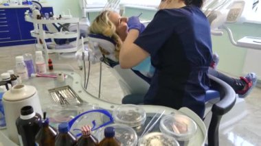 Kiev, Ukrayna-Nisan 2019: kız dişçi resepsiyonunda. Dişçi diş hekimliği ofisinde hastaya diş davranır. Diş hekimi klinikte hasta davranır.