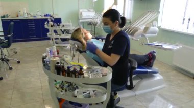 Kiev, Ukrayna-Nisan 2019: kız dişçi resepsiyonunda. Dişçi diş hekimliği ofisinde hastaya diş davranır. Diş hekimi klinikte hasta davranır.
