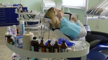 Kiev, Ukrayna-Nisan 2019: kız dişçi resepsiyonunda. Dişçi diş hekimliği ofisinde hastaya diş davranır. Diş hekimi klinikte hasta davranır.