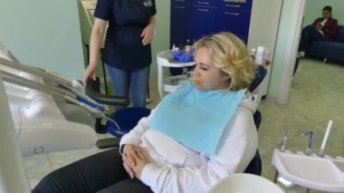 Kiev, Ukrayna-Nisan 2019: kız dişçi resepsiyonunda. Dişçi diş hekimliği ofisinde hastaya diş davranır. Diş hekimi klinikte hasta davranır.