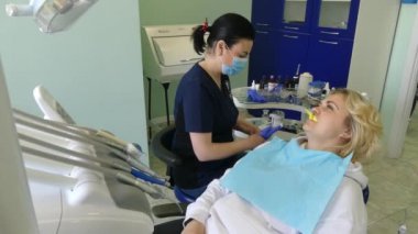 Kiev, Ukrayna-Nisan 2019: kız dişçi resepsiyonunda. Dişçi diş hekimliği ofisinde hastaya diş davranır. Diş hekimi klinikte hasta davranır.