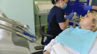 Kiev, Ukrayna-Nisan 2019: kız dişçi resepsiyonunda. Dişçi diş hekimliği ofisinde hastaya diş davranır. Diş hekimi klinikte hasta davranır.