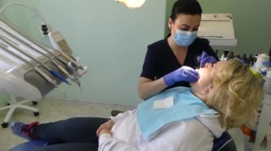 Kiev, Ukrayna-Nisan 2019: kız dişçi resepsiyonunda. Dişçi diş hekimliği ofisinde hastaya diş davranır. Diş hekimi klinikte hasta davranır.