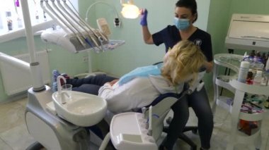 Kiev, Ukrayna-Nisan 2019: kız dişçi resepsiyonunda. Dişçi diş hekimliği ofisinde hastaya diş davranır. Diş hekimi klinikte hasta davranır.