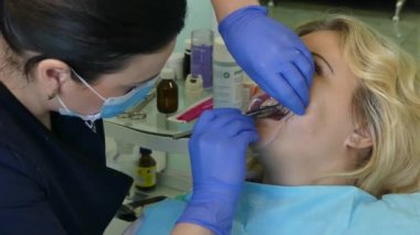 Kiev, Ukrayna-Nisan 2019: kız dişçi resepsiyonunda. Dişçi diş hekimliği ofisinde hastaya diş davranır. Diş hekimi klinikte hasta davranır.