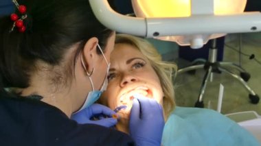 Kiev, Ukrayna-Nisan 2019: kız dişçi resepsiyonunda. Dişçi diş hekimliği ofisinde hastaya diş davranır. Diş hekimi klinikte hasta davranır.