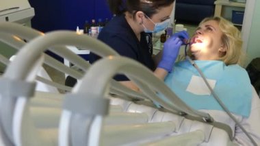 Kiev, Ukrayna-Nisan 2019: kız dişçi resepsiyonunda. Dişçi diş hekimliği ofisinde hastaya diş davranır. Diş hekimi klinikte hasta davranır.