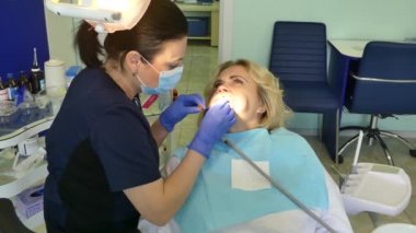 Kiev, Ukrayna-Nisan 2019: kız dişçi resepsiyonunda. Dişçi diş hekimliği ofisinde hastaya diş davranır. Diş hekimi klinikte hasta davranır.