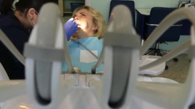 Kiev, Ukrayna-Nisan 2019: kız dişçi resepsiyonunda. Dişçi diş hekimliği ofisinde hastaya diş davranır. Diş hekimi klinikte hasta davranır.