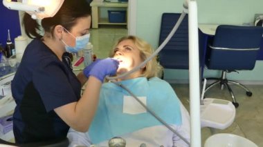 Kiev, Ukrayna-Nisan 2019: kız dişçi resepsiyonunda. Dişçi diş hekimliği ofisinde hastaya diş davranır. Diş hekimi klinikte hasta davranır.