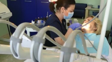 Kiev, Ukrayna-Nisan 2019: kız dişçi resepsiyonunda. Dişçi diş hekimliği ofisinde hastaya diş davranır. Diş hekimi klinikte hasta davranır.
