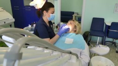 Kiev, Ukrayna-Nisan 2019: kız dişçi resepsiyonunda. Dişçi diş hekimliği ofisinde hastaya diş davranır. Diş hekimi klinikte hasta davranır.