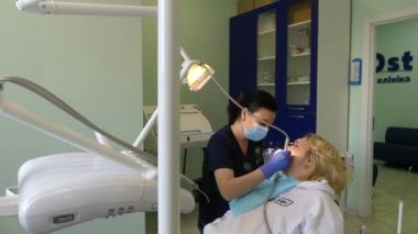 Kiev, Ukrayna-Nisan 2019: kız dişçi resepsiyonunda. Dişçi diş hekimliği ofisinde hastaya diş davranır. Diş hekimi klinikte hasta davranır.