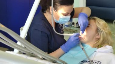 Kiev, Ukrayna-Nisan 2019: kız dişçi resepsiyonunda. Dişçi diş hekimliği ofisinde hastaya diş davranır. Diş hekimi klinikte hasta davranır.