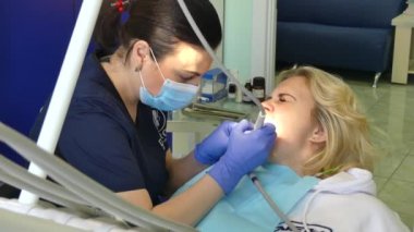 Kiev, Ukrayna-Nisan 2019: kız dişçi resepsiyonunda. Dişçi diş hekimliği ofisinde hastaya diş davranır. Diş hekimi klinikte hasta davranır.