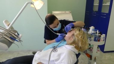 Kiev, Ukrayna-Nisan 2019: kız dişçi resepsiyonunda. Dişçi diş hekimliği ofisinde hastaya diş davranır. Diş hekimi klinikte hasta davranır.