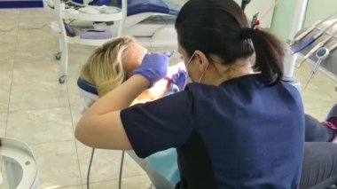 Kiev, Ukrayna-Nisan 2019: kız dişçi resepsiyonunda. Dişçi diş hekimliği ofisinde hastaya diş davranır. Diş hekimi klinikte hasta davranır.