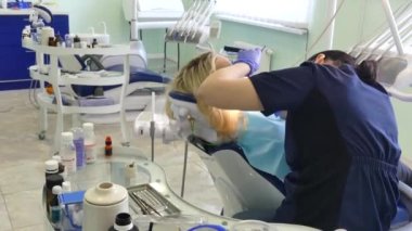Kiev, Ukrayna-Nisan 2019: kız dişçi resepsiyonunda. Dişçi diş hekimliği ofisinde hastaya diş davranır. Diş hekimi klinikte hasta davranır.