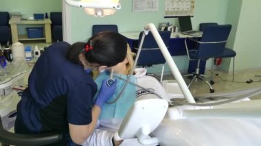 Kiev, Ukrayna-Nisan 2019: kız dişçi resepsiyonunda. Dişçi diş hekimliği ofisinde hastaya diş davranır. Diş hekimi klinikte hasta davranır.