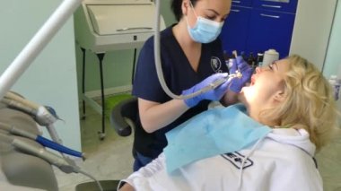 Kiev, Ukrayna-Nisan 2019: kız dişçi resepsiyonunda. Dişçi diş hekimliği ofisinde hastaya diş davranır. Diş hekimi klinikte hasta davranır.