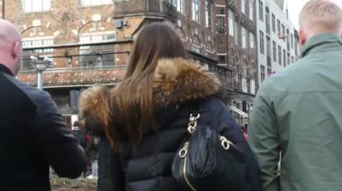 Kopenhag, Danimarka - Mart 2019: Turistler bir şehir caddesi boyunca yürüyor. Şehirde dolaş. Sokakların manzarası.