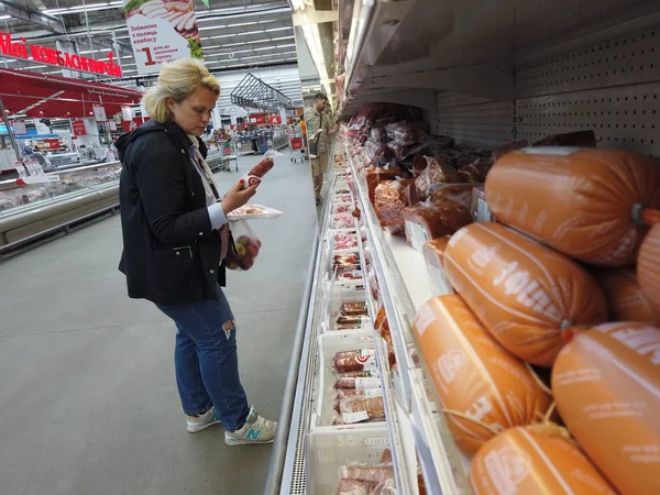 Os compradores escolhem a carne no balcão do hipermercado. Carne depar — Fotografia de Stock