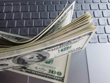 Dizüstü Klavye arka planda Amerikan Doları yığını. Çok o