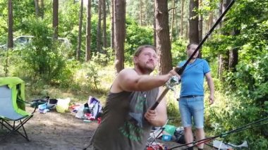 Orman gölünde balıkçılık. Bir adam balık tutmaya atıyor. Adam ormanda gölde balıklar.