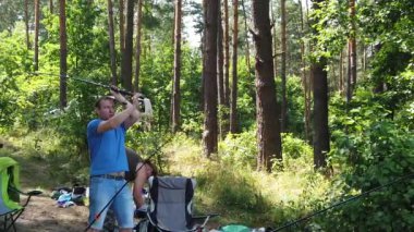 Orman gölünde balıkçılık. Bir adam balık tutmaya atıyor. Adam ormanda gölde balıklar.