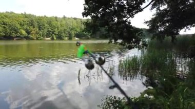 Orman gölünde balıkçılık. Balıkçılık sırasında Spinning üzerinde çan.