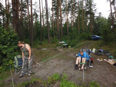 Ormanda balıkçılık yaparken sahilde balıkçılık çubukları olan bir adam ben