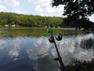 Orman gölünde balıkçılık. Balıkçılık sırasında Spinning üzerinde çan.