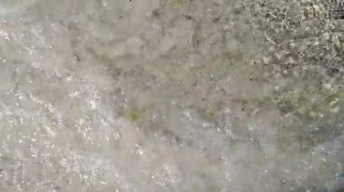 Kumlu deniz suyu sahili yıkar. Yavaş çekim.