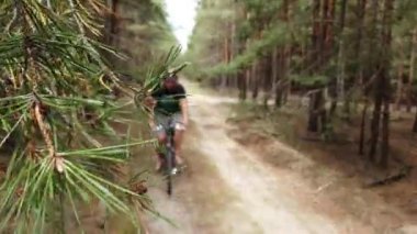 Kiev, Ukrayna, Avrupa - Ağustos 2019: Orman yolunda bisiklet sürmek. Ormanda bir bisikletçi bir yolda gidiyor. Ormanda bisiklet turu.