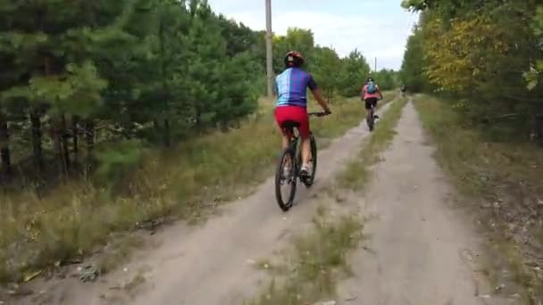 キエフ ウクライナ ヨーロッパ 8月2019 森林道路上の自転車に乗る サイクリストが森の中の道を走る 森を自転車で巡るツアー — ストック動画