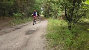 Kiev, Ukrayna, Avrupa - Ağustos 2019: Orman yolunda bisiklet sürmek. Ormanda bir bisikletçi bir yolda gidiyor. Ormanda bisiklet turu.