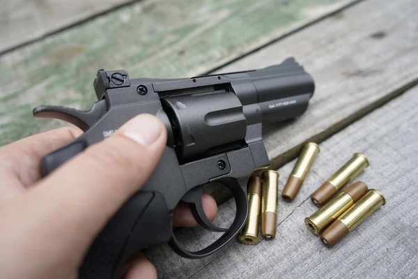 Air gun with cartridges on a wooden background.