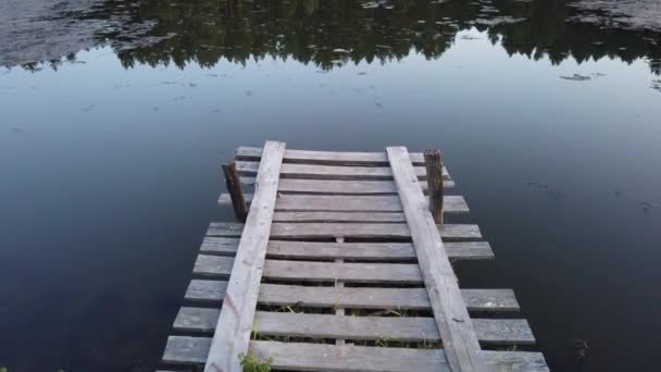 Vieille chaussée en bois sur le fond d'un lac forestier .