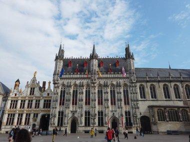 Bruges, Belçika - Mayıs 2019 Gruuthuse Sarayı manzarası. Bölge sarayın daha ilerisinde. Turistler yürür.