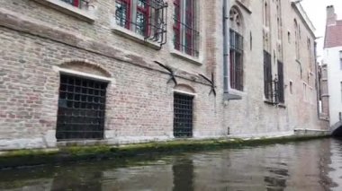 Bruges, Belçika - Mayıs 2019: Şehir merkezindeki su kanalının görünümü. Turist şehrin su kanalları üzerinde yürümek. Bir turist teknesinden görünüm.