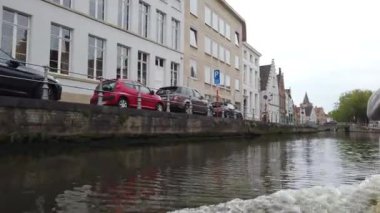 Bruges, Belçika - Mayıs 2019: Şehir merkezindeki su kanalının görünümü. Turist şehrin su kanalları üzerinde yürümek. Bir turist teknesinden görünüm.